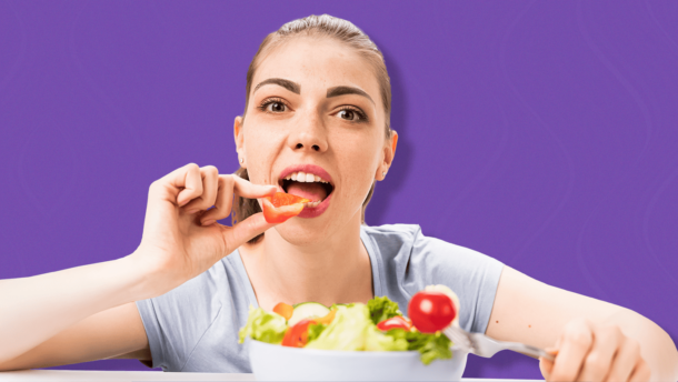 Mujer sosteniendo verdura en la mano y con plato de ensalada